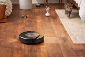 Le robot aspirateur et laveur de sol Roomba Combo J7 en action ssur le parquet en bois d'un salon