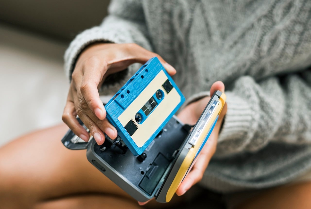 Une jeune femme insérant une cassette audio dans son walkman