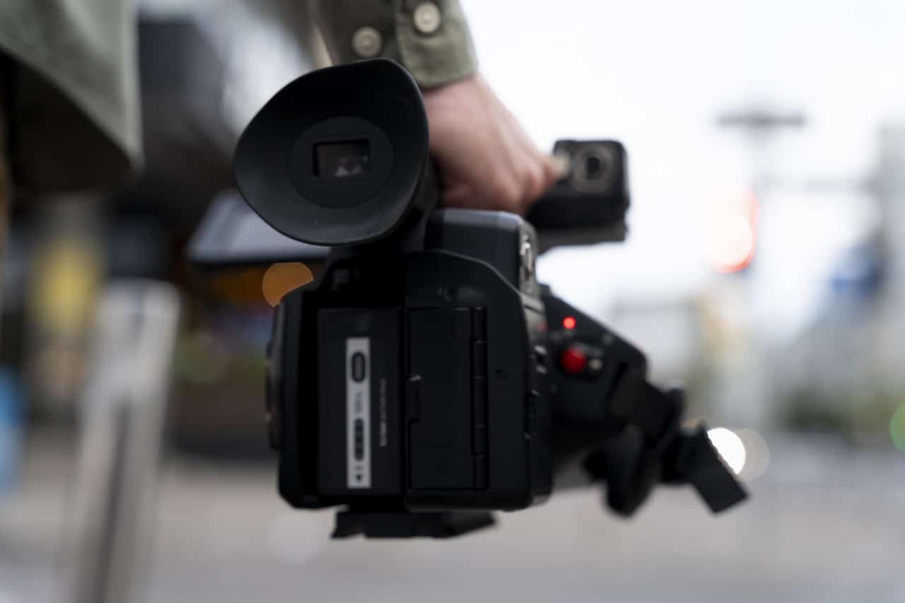 Un homme tenant à la main un caméscope semi pro