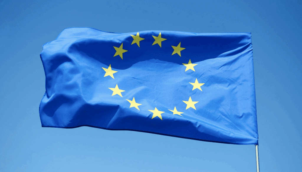 Le drapeau de l'union européenne devant un ciel bleu.