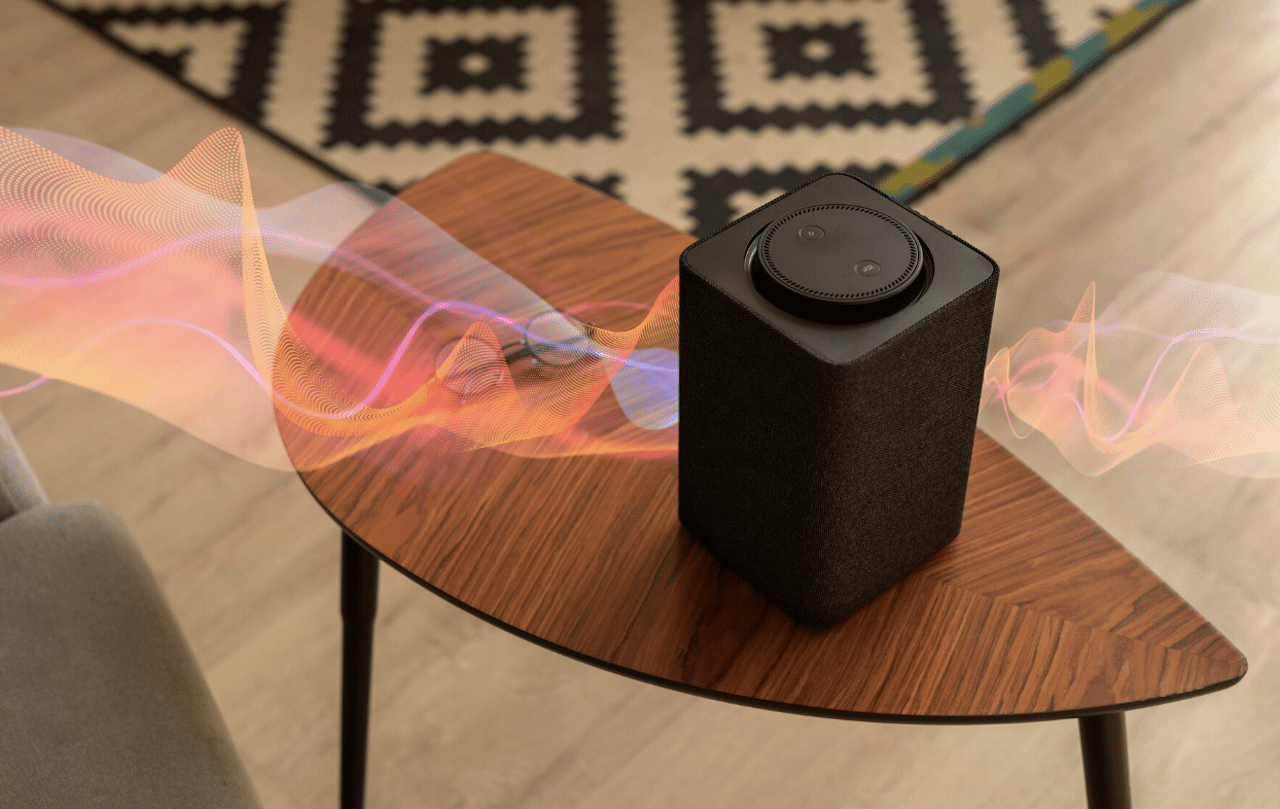 Une enceinte portable posée sur une table en bois.