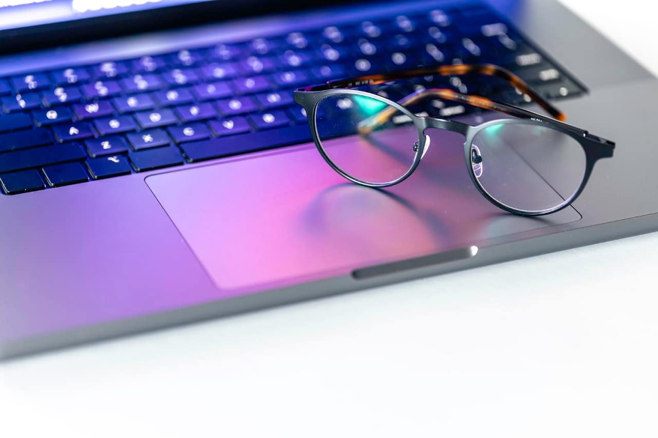 Des lunettes anti lumière bleue posée sur le clavier d'un ordinateur portable