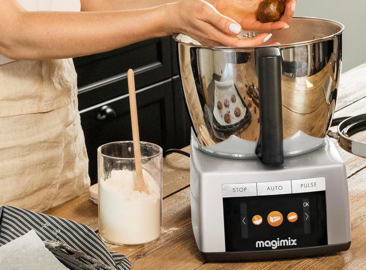 Une femme fait de la pâtisserie avec un robot cuiseur de la marque Magimix.