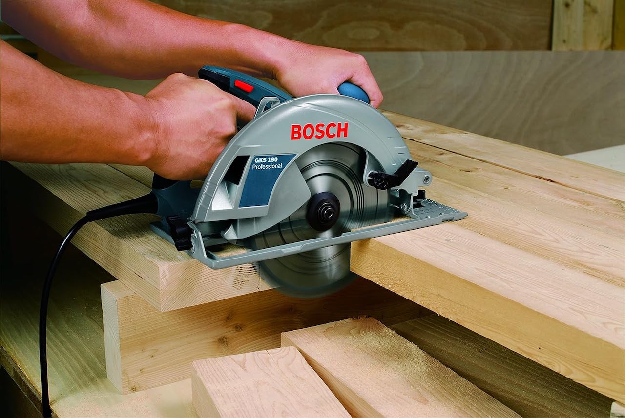 Un homme en train d'utiliser une scie circulaire de la marque Bosch.