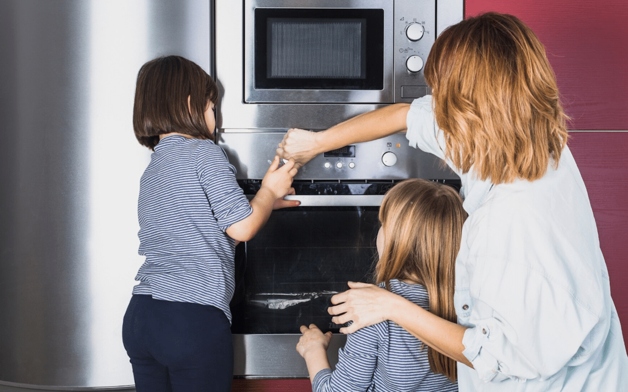 Des enfants et leur mère en train de préparer le four.
