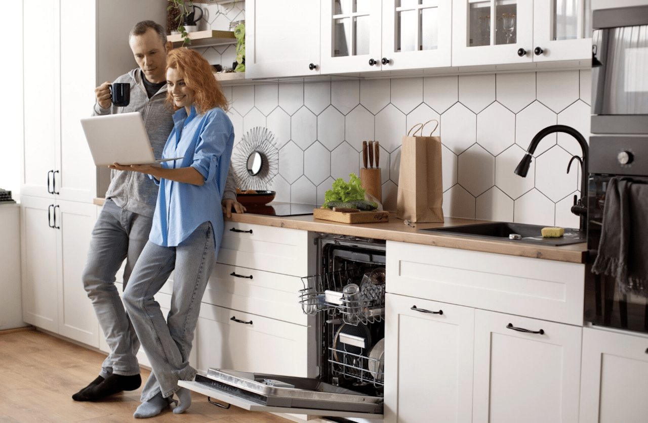 Un couple dans une cuisine équipée d'appareils électroménagers.
