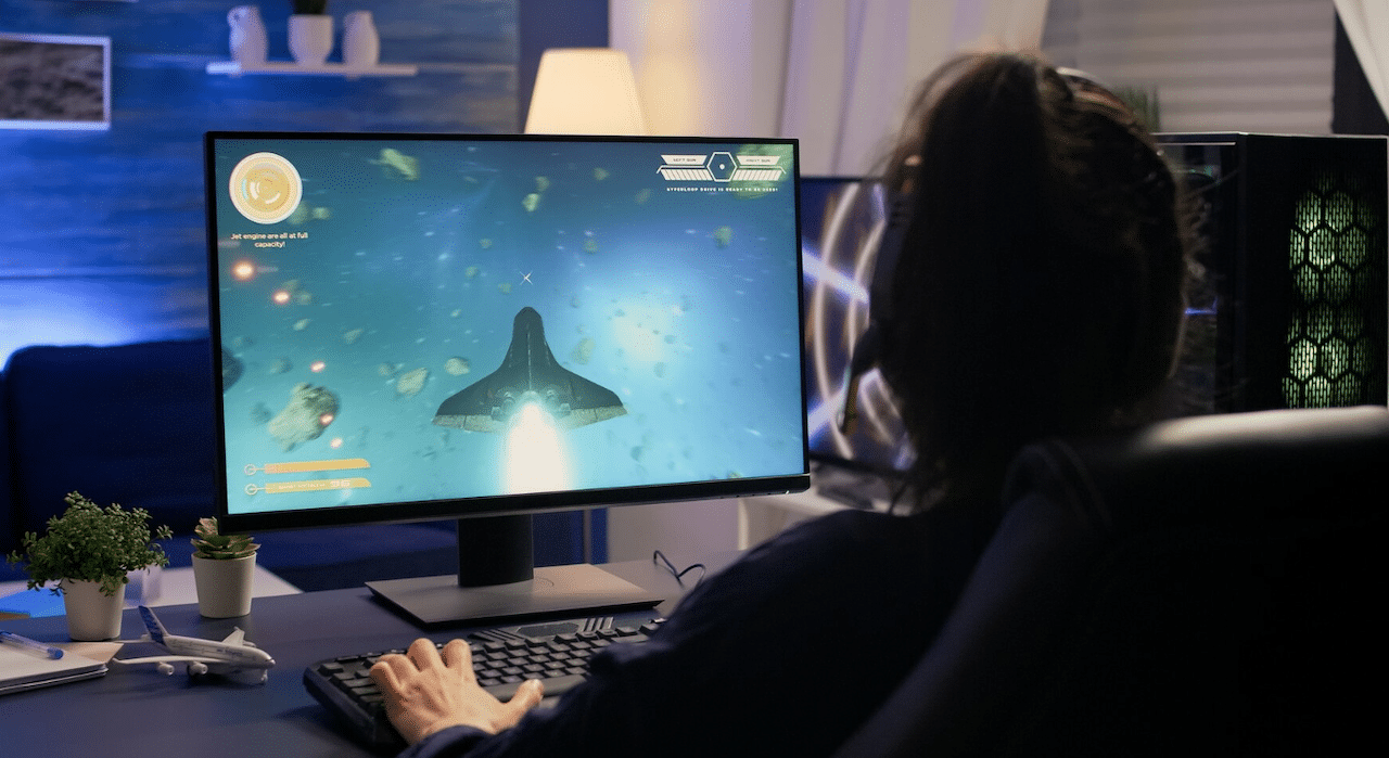 Un homme en train de jouer à des jeux vidéos sur son écran de gaming.