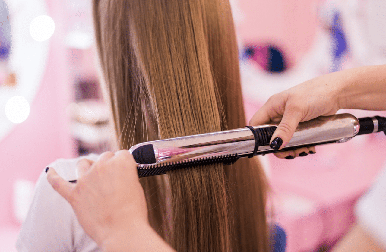 Une fille en train de se faire lisser les cheveux.
