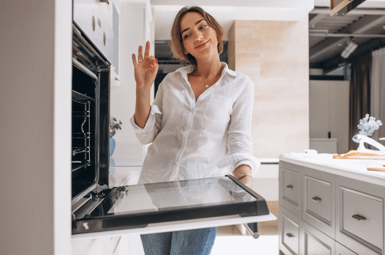 Une femme dans une cuisine qui ouvre son four encastrable.