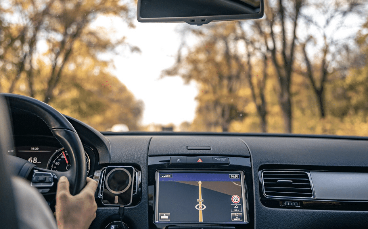 Une femme qui conduit une voiture en automne.