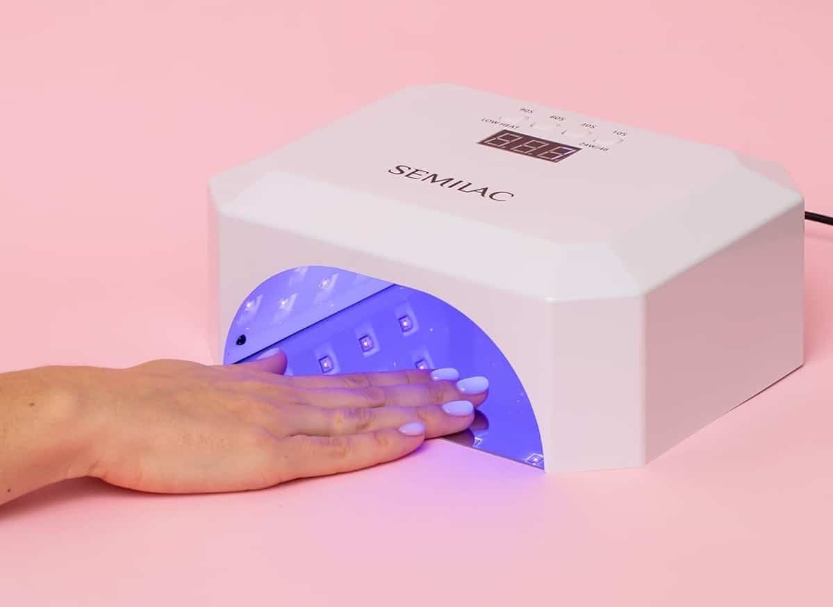 Une femme utilisant la lampe UV pour ongles en gel de la marque Semilac