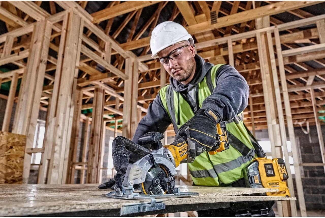 Un homme en train d'utiliser une scie circulaire de la marque DeWalt.