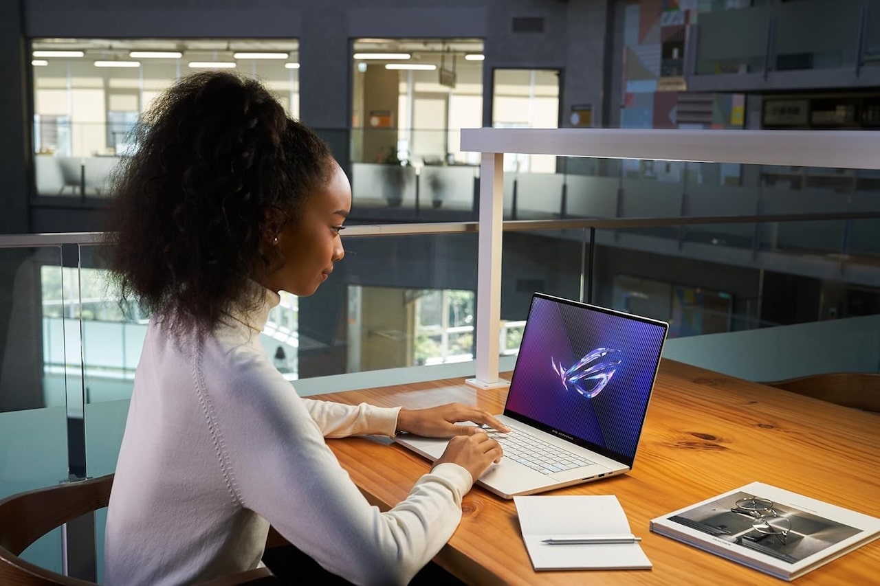 Une femme au travail en train d'utiliser un ordinateur portable de la marque Asus.