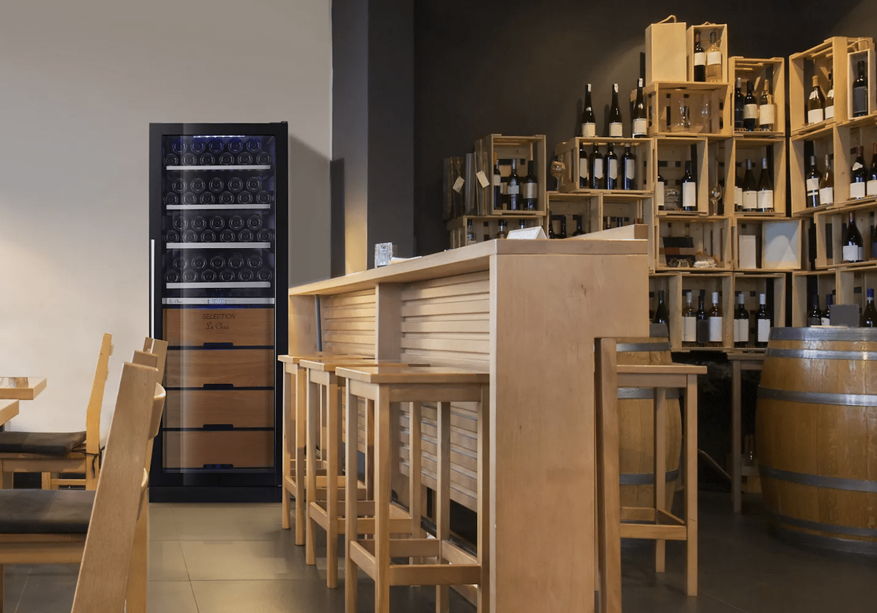 Une cave à vin de vieillissement de la marque Le Chai, entourée de caisses de vin.