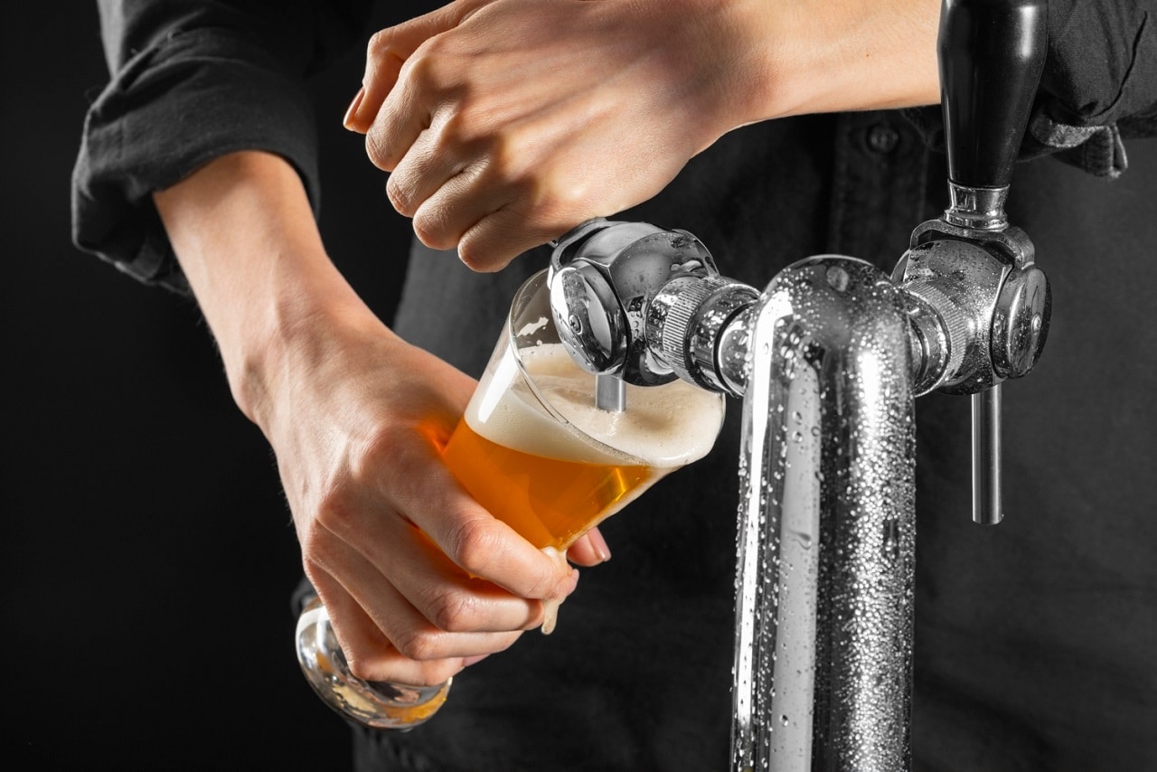 Gros plan sur un homme utilisant une tireuse à bière