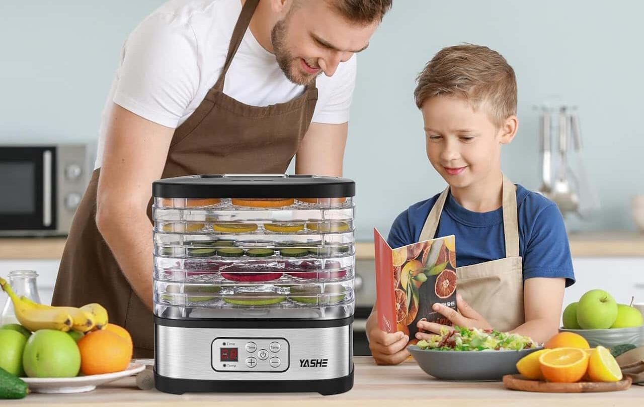 Un père et son fils qui utilisent un déshydrateur alimentaire.