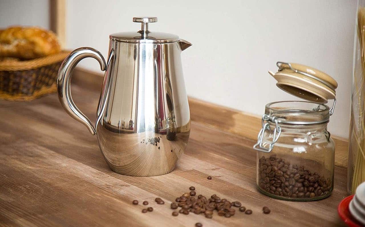 Une cafetière à piston sur un plan de travail en bois.