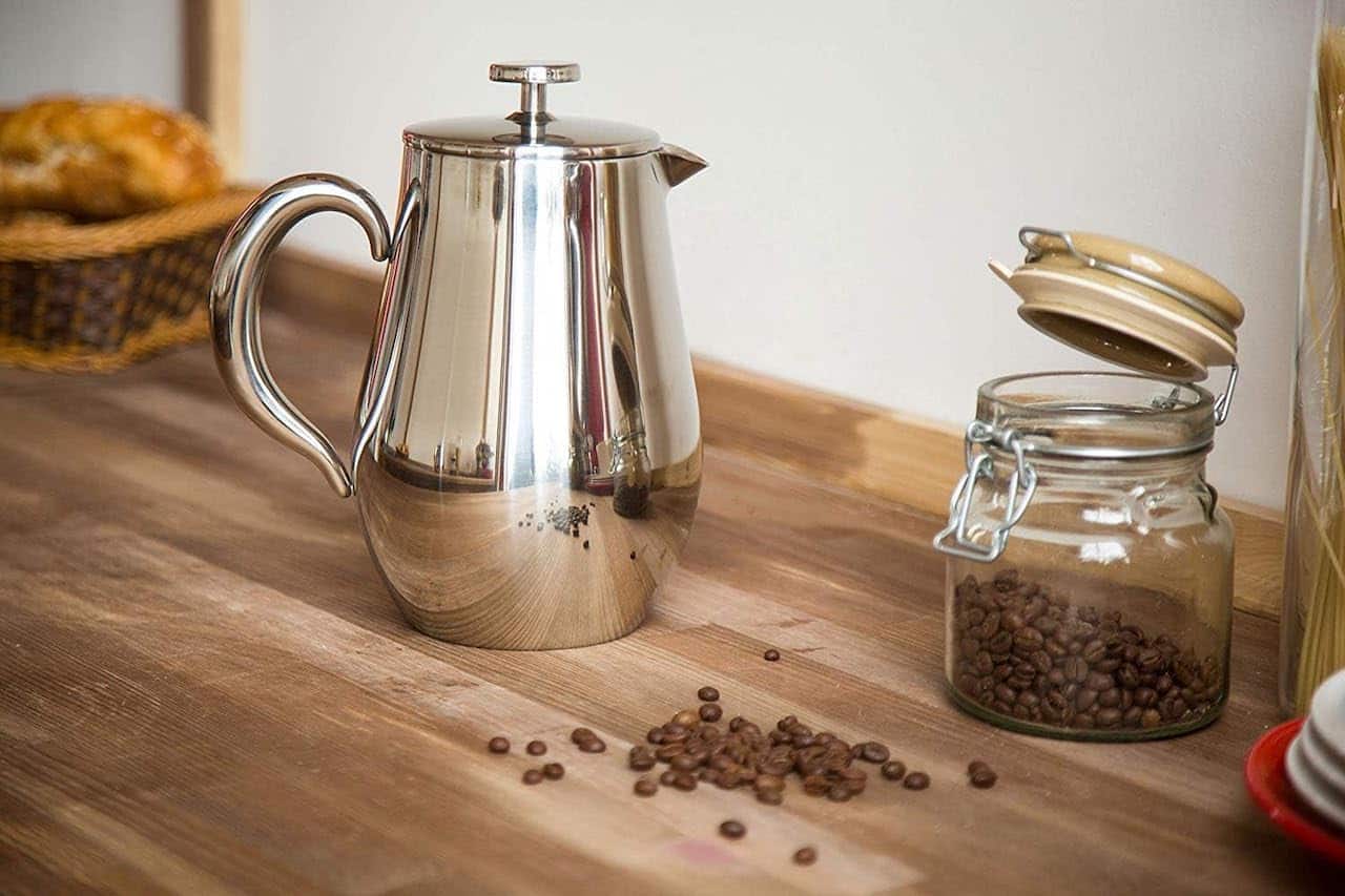 Une cafetière à piston sur un plan de travail en bois.