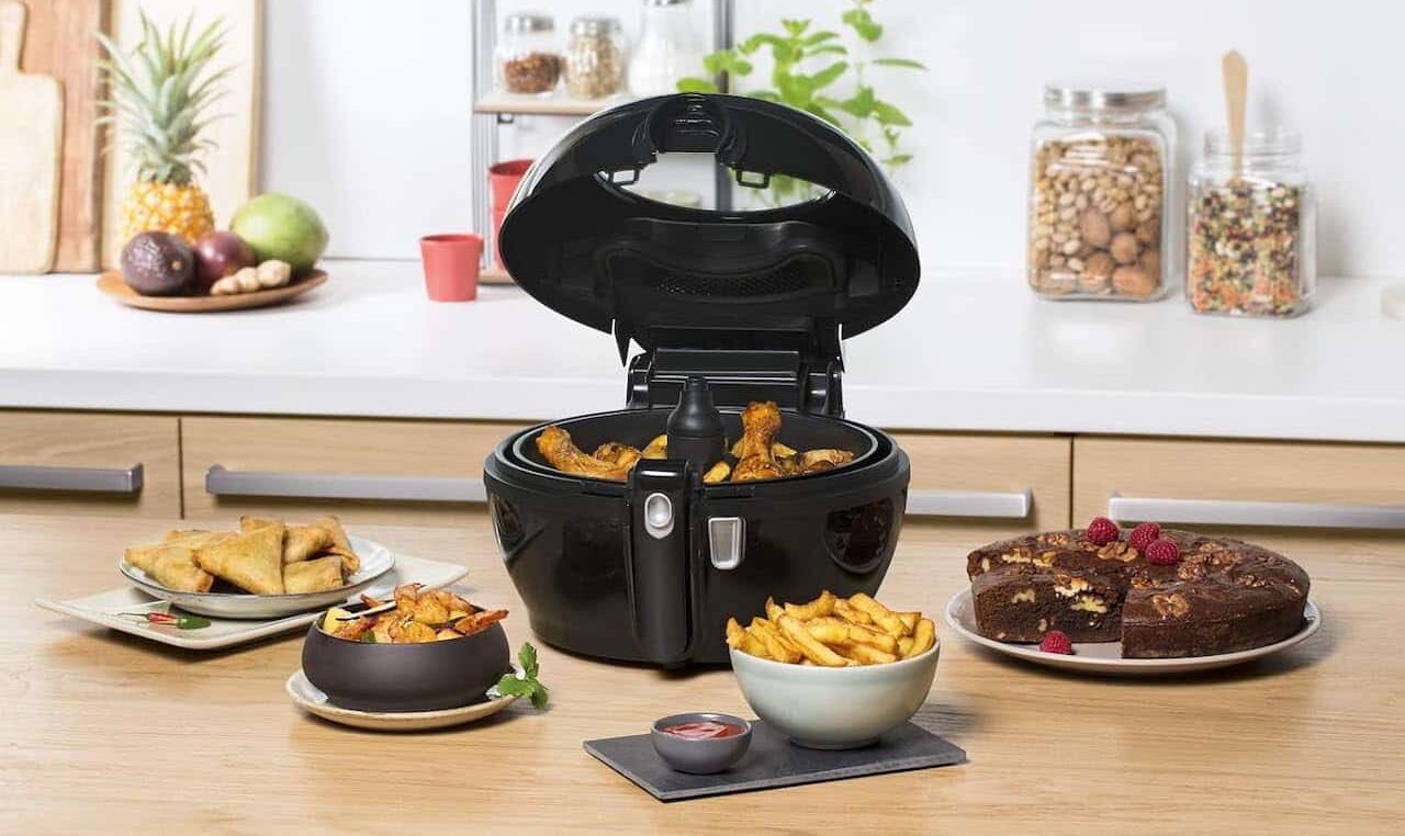 Une friteuse SEB entourée de bol de nourriture.