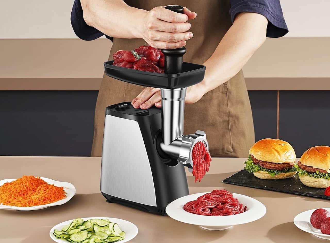 Une personne qui utilise un hachoir à viande pour préparer des burgers.