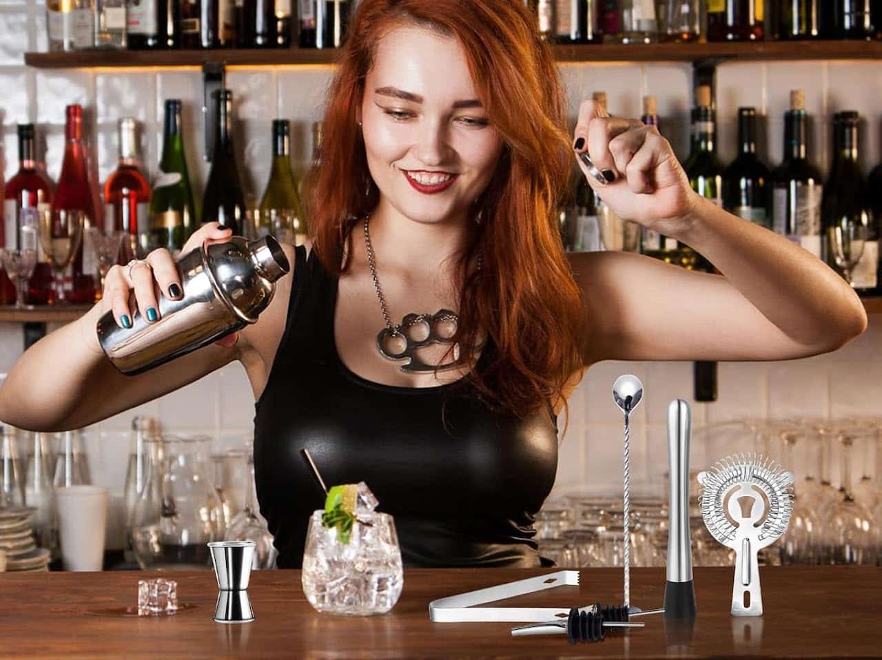 Une barmaid qui prépare un cocktail à l'aide d'un shaker à cocktail.