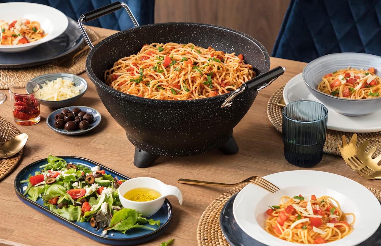 Une table dressée avec un wok électrique.