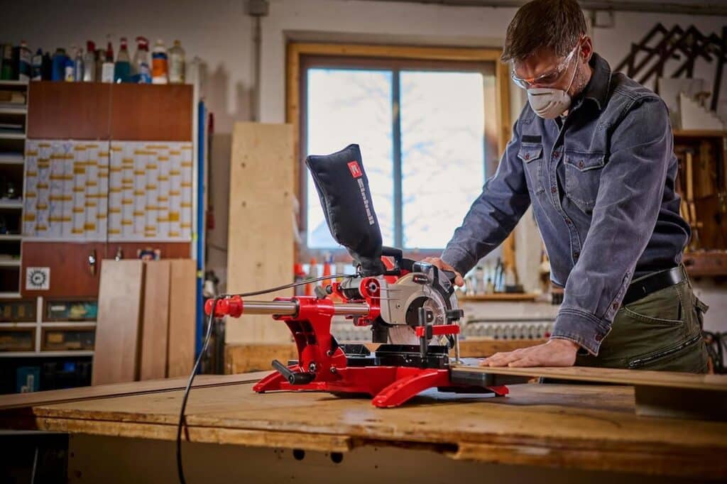 Un homme qui se sert d'une scie à onglet de la marque Einhell.