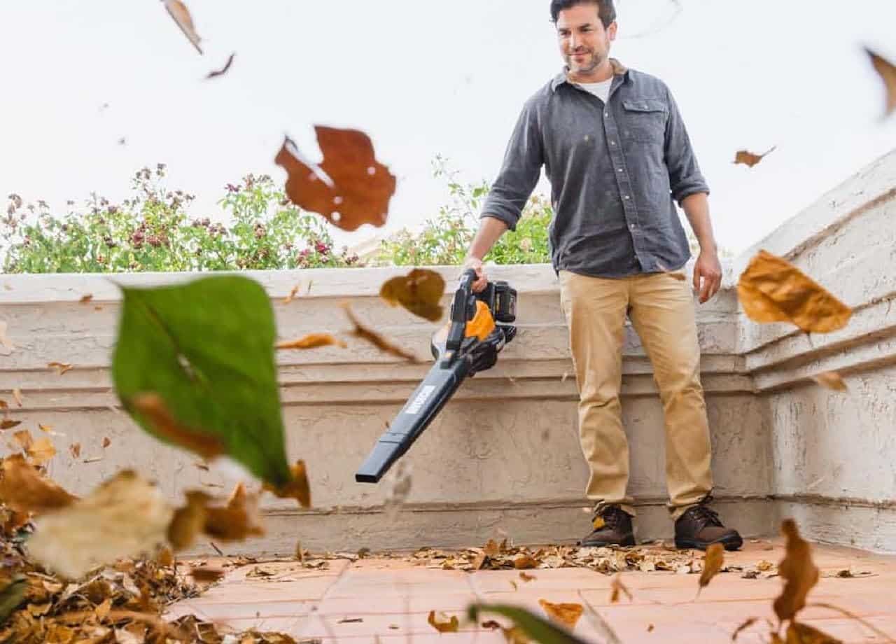 Un homme qui utilise un souffleur de la marque WORX.