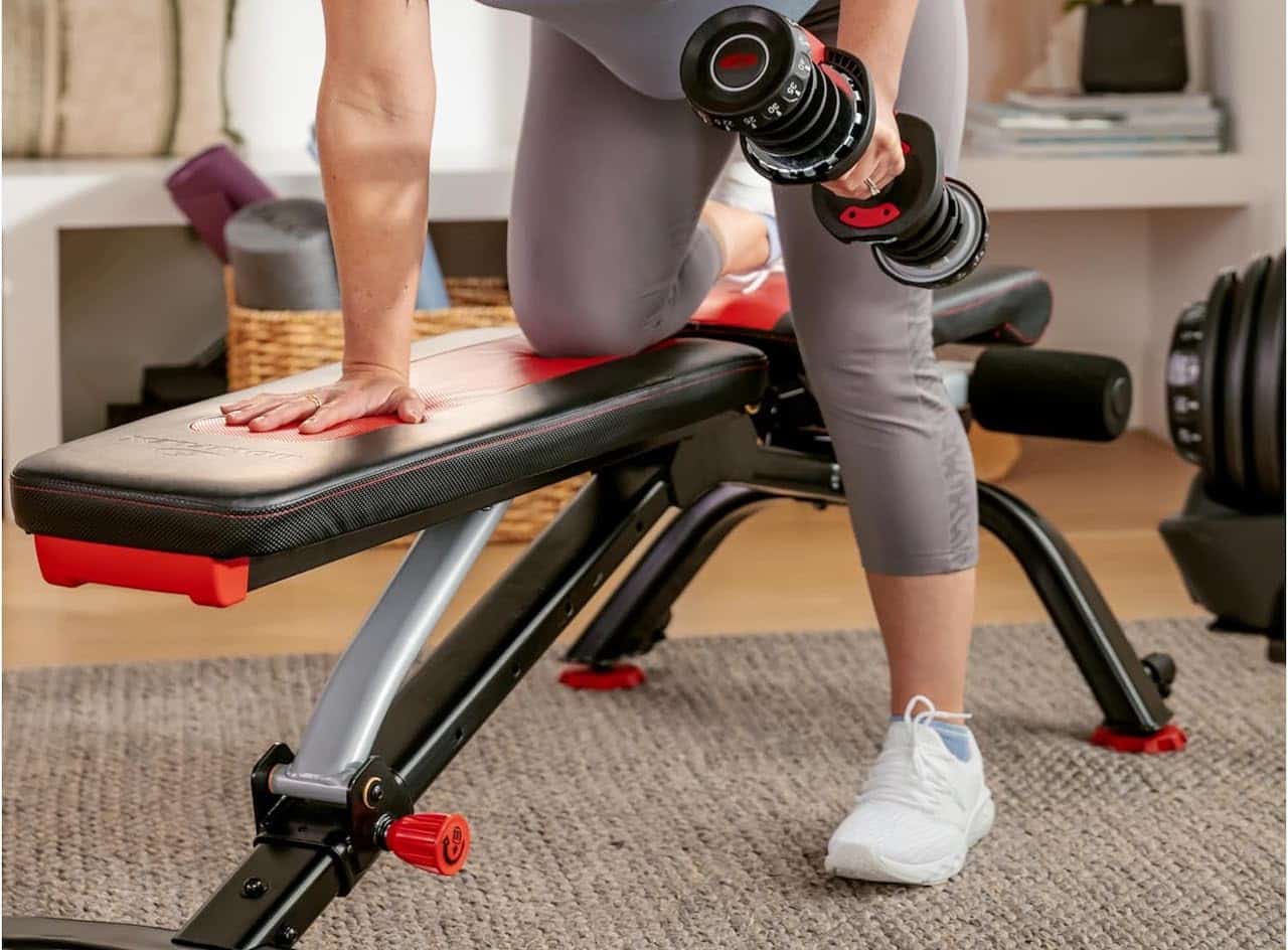 Une femme qui fait du sport sur un banc de musculation.