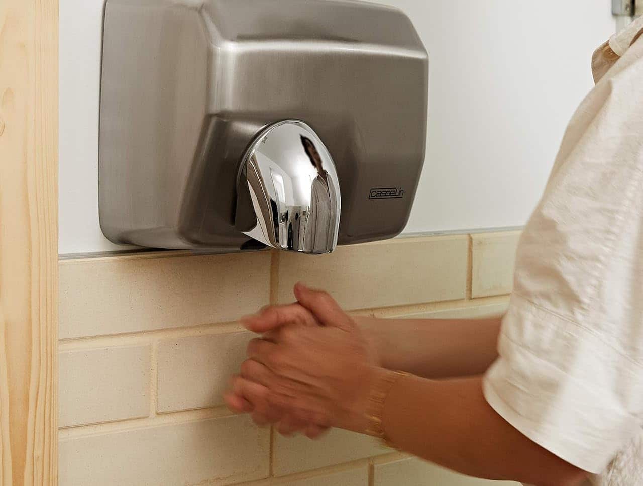 Un homme qui utilise un sèche-mains.