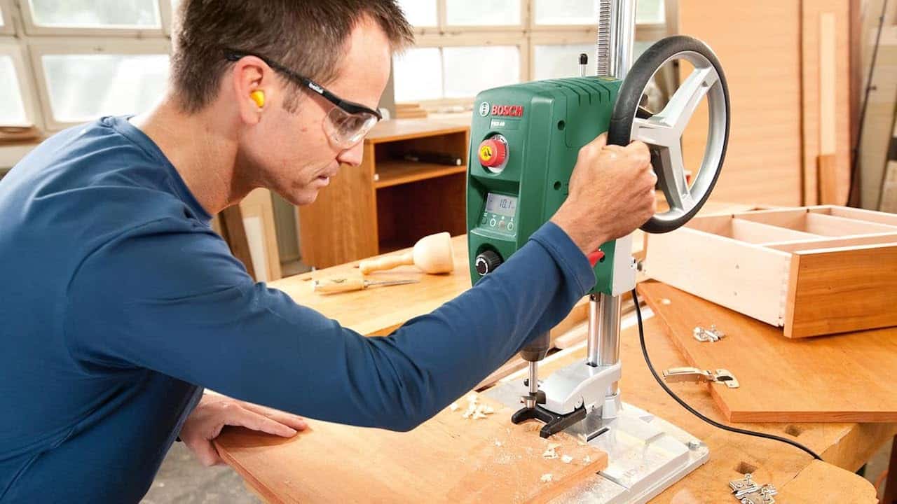 Un homme qui utilise une perceuse à colonne de chez Bosch.
