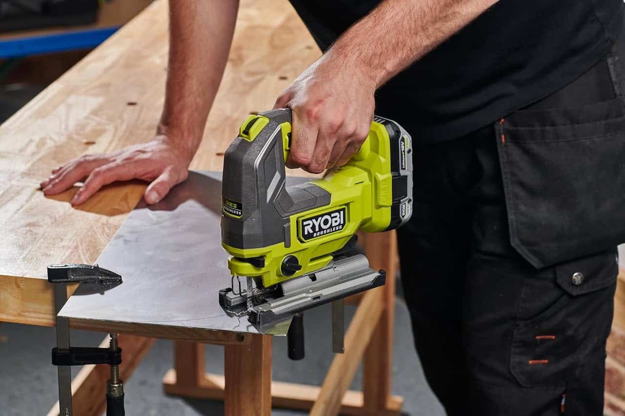 Un homme qui utilise une scie sauteuse de la marque Ryobi.