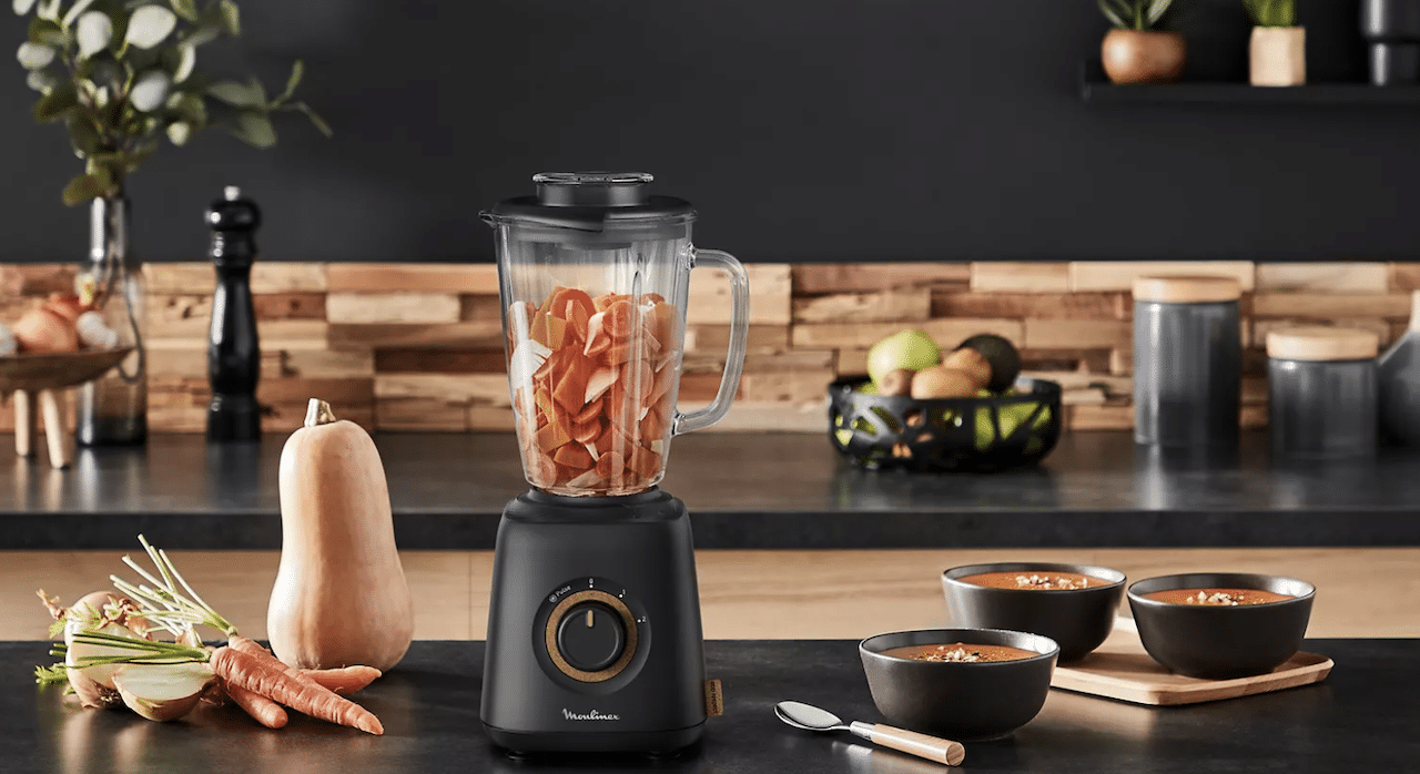 Une cuisine moderne avec un blender et des aliments à côté.