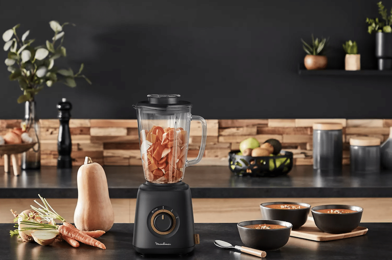 Une cuisine moderne avec un blender et des aliments à côté.