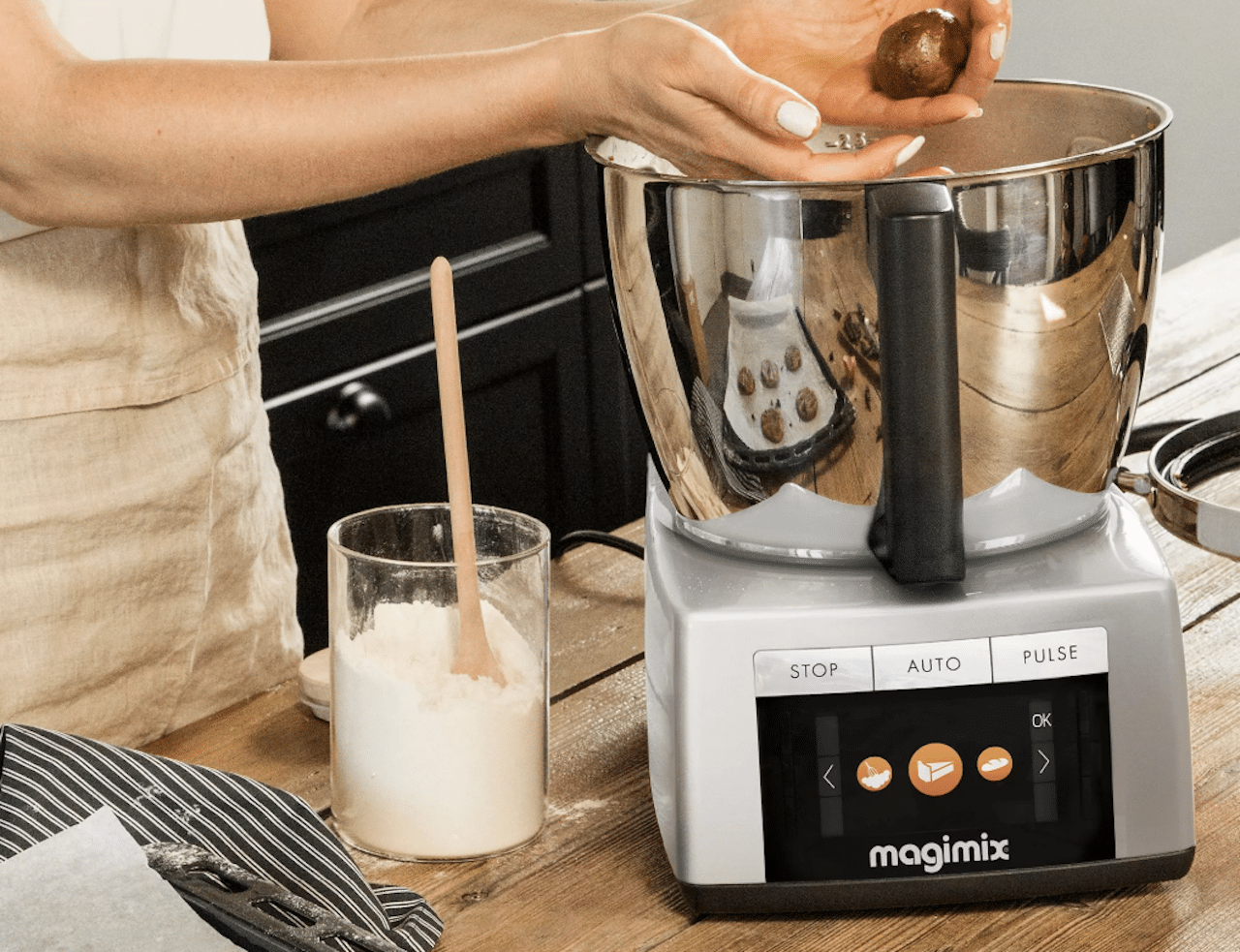 Une femme qui cuisine avec un robot cuiseur.