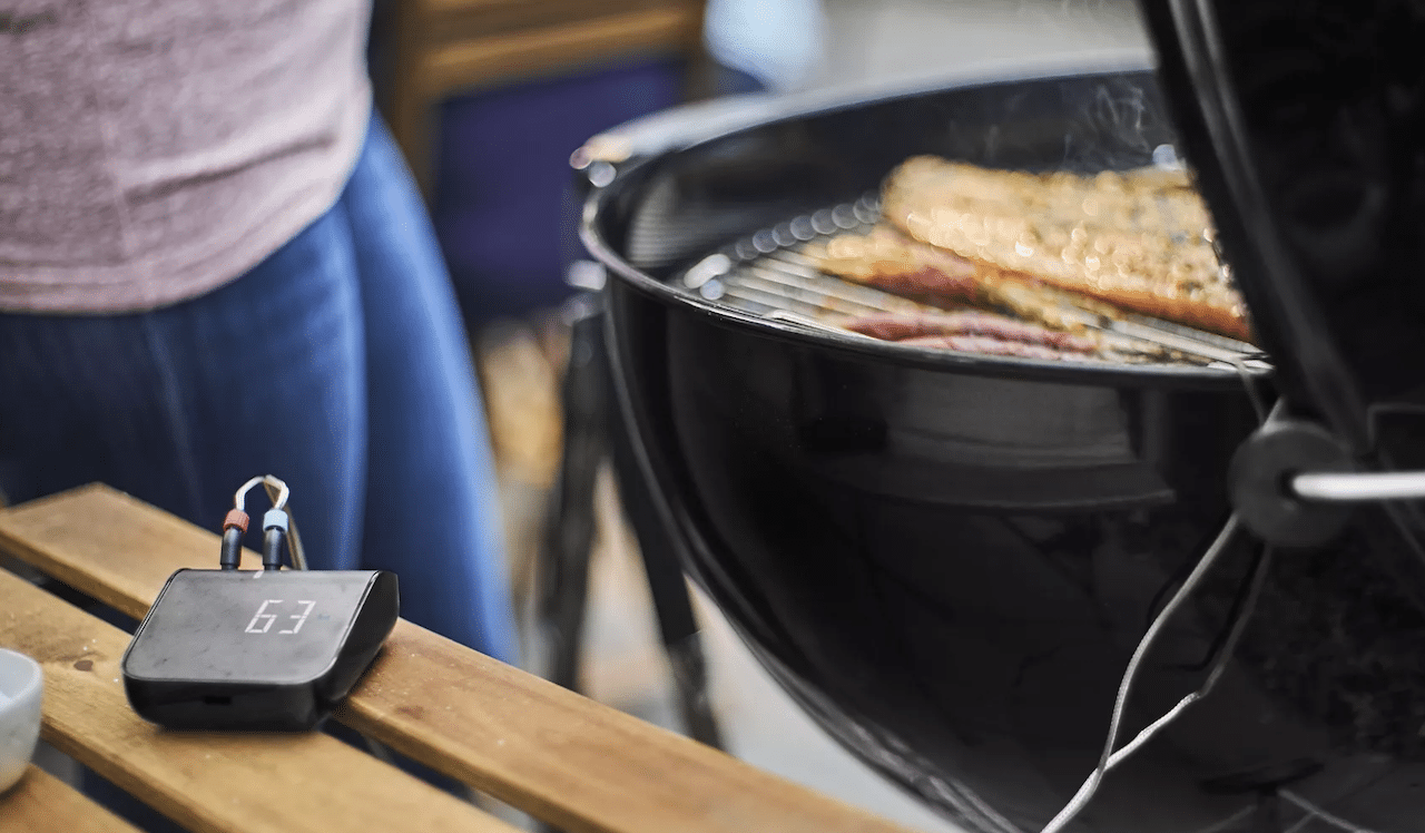 Une personne qui utilise un thermomètre de cuisson pour le barbecue.