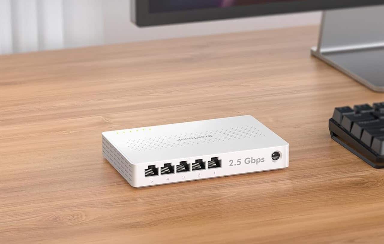 Un switch Ethernet posé sur un bureau en bois.