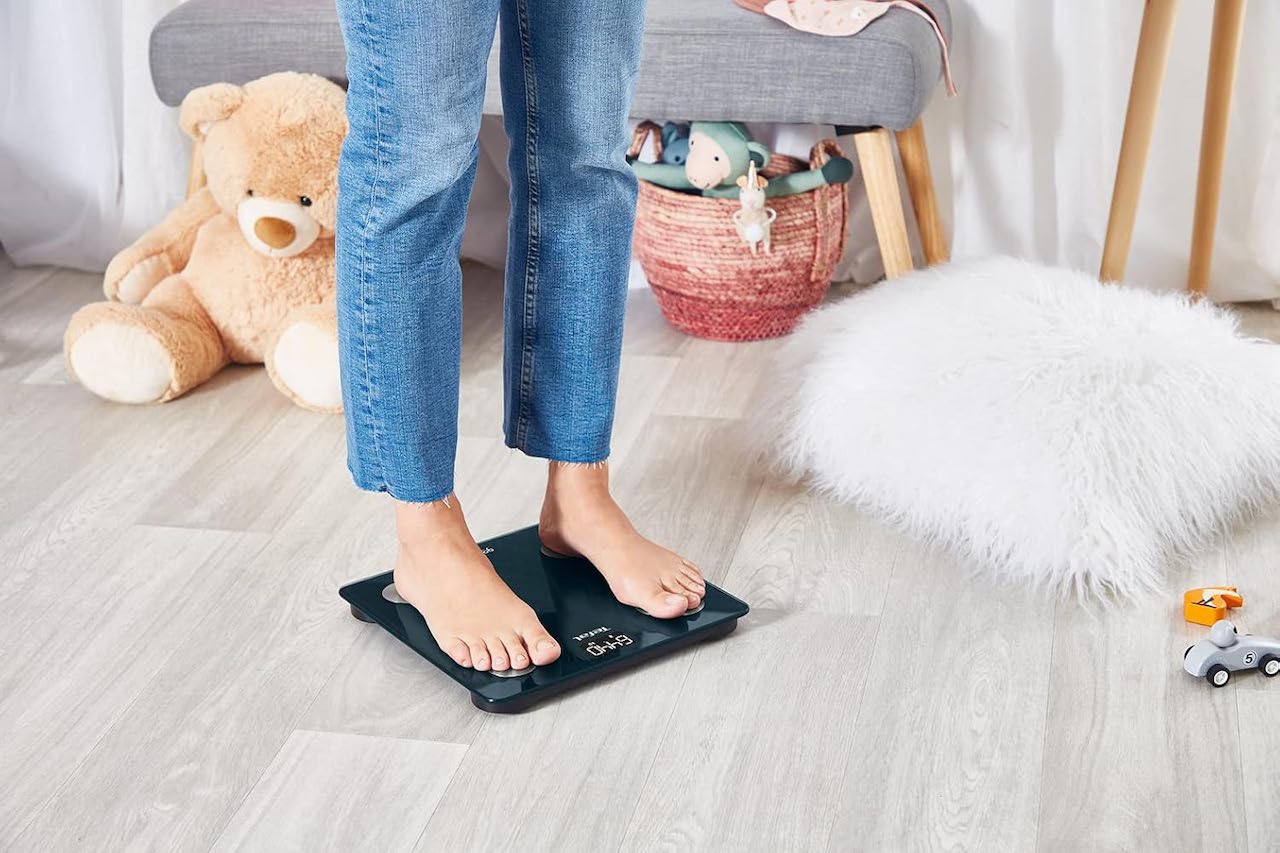 Une femme qui se pèse sur un pèse-personne.
