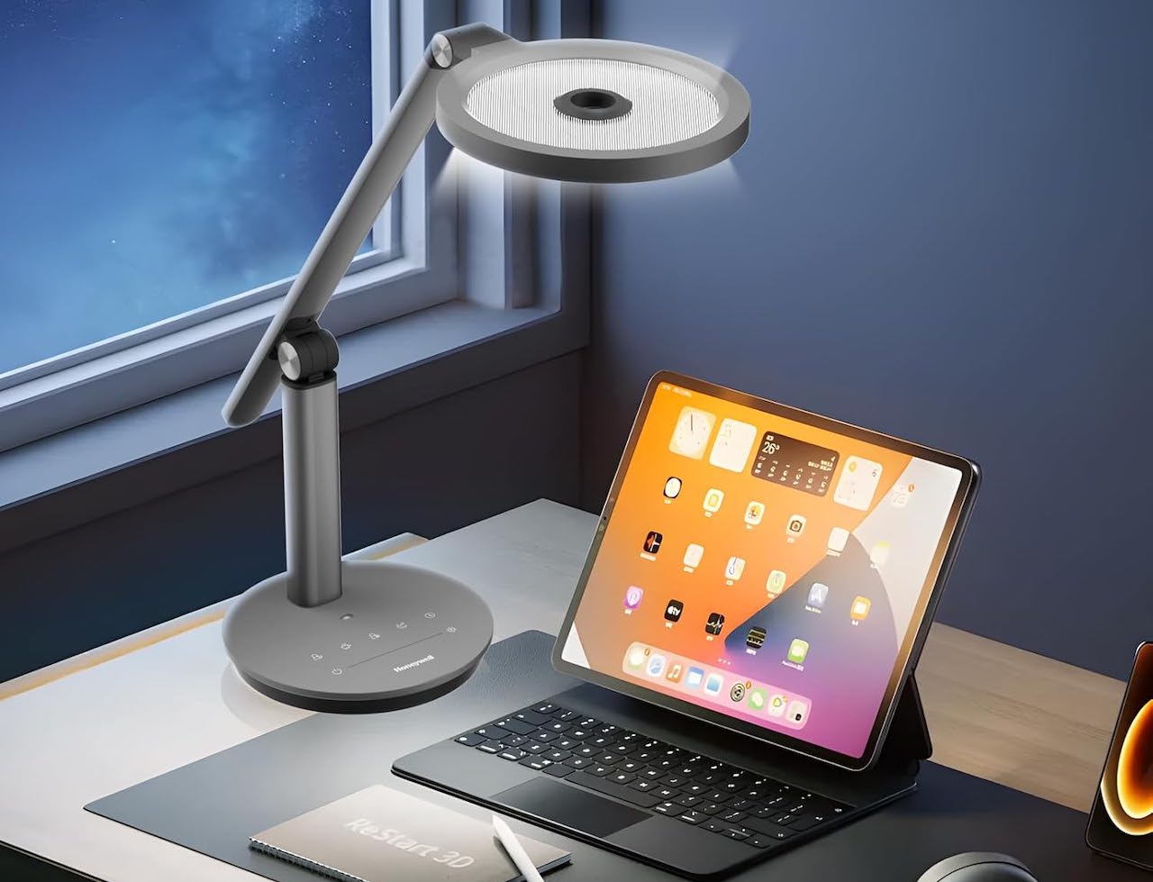Une lampe de bureau et une tablette tactile sur un bureau.