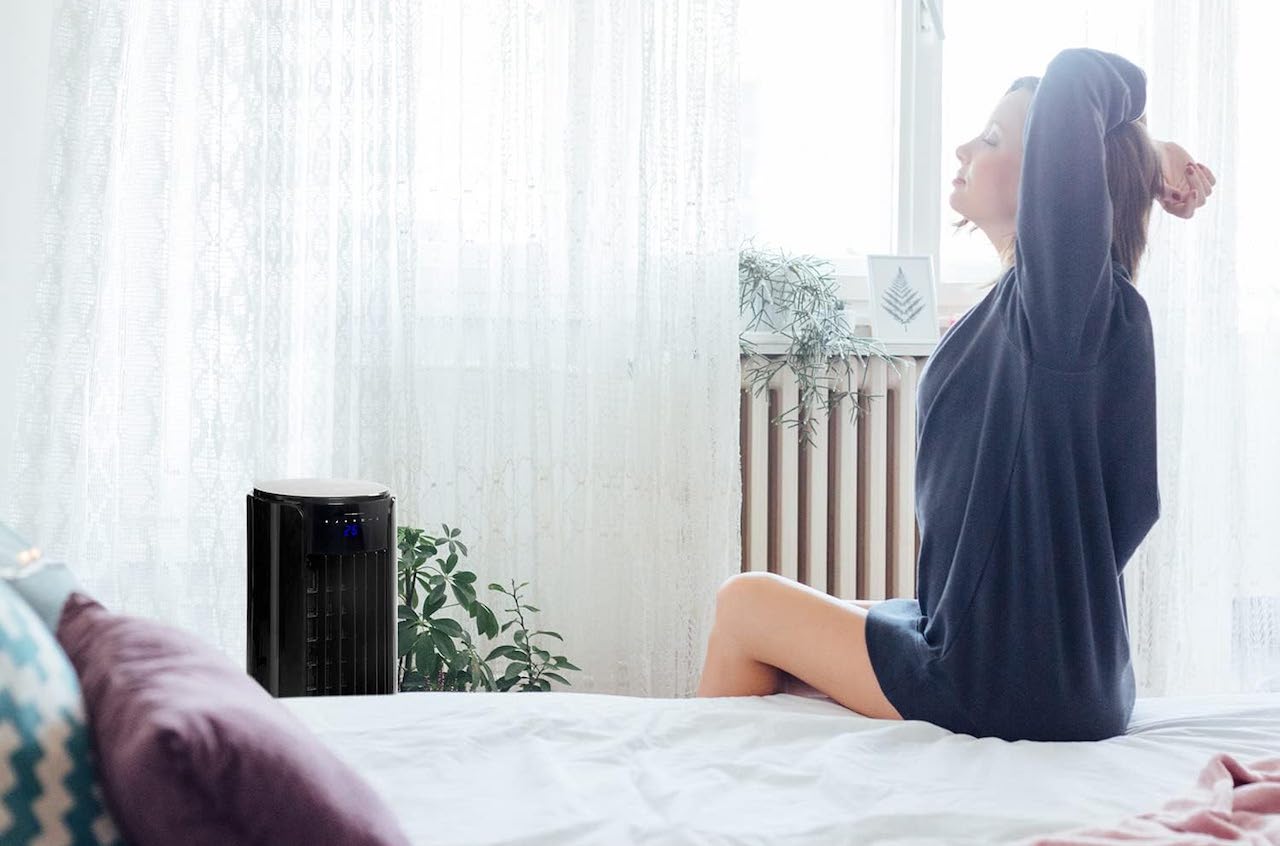 Une femme dans sa chambre avec un rafraîchisseur d'air.