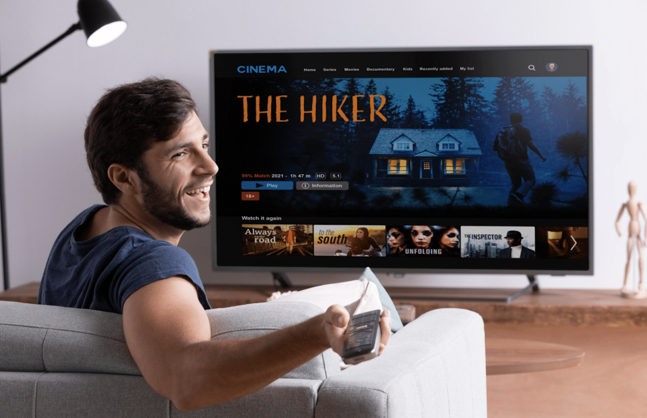 Un homme qui regarde une série sur sa TV 8K.