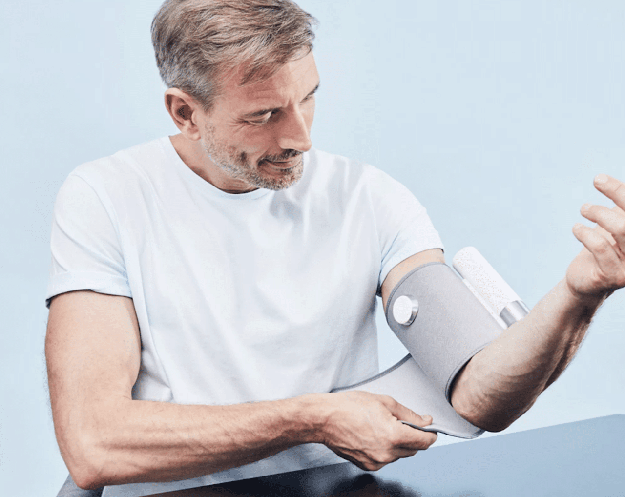 Un homme qui utilise un tensiomètre de la marque Withings.
