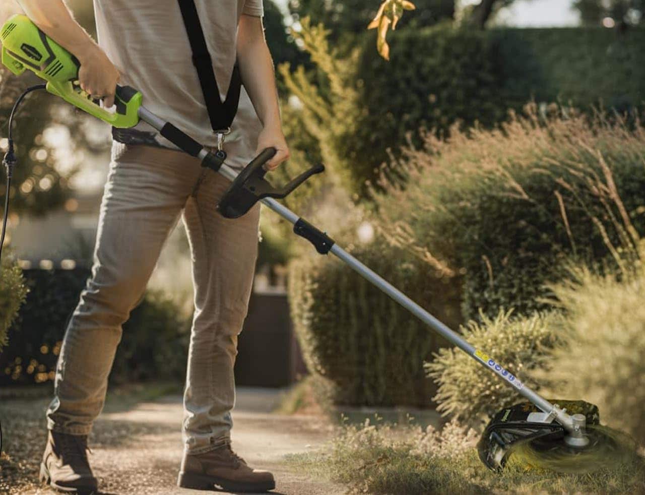 Un homme qui utilise une débroussailleuse.