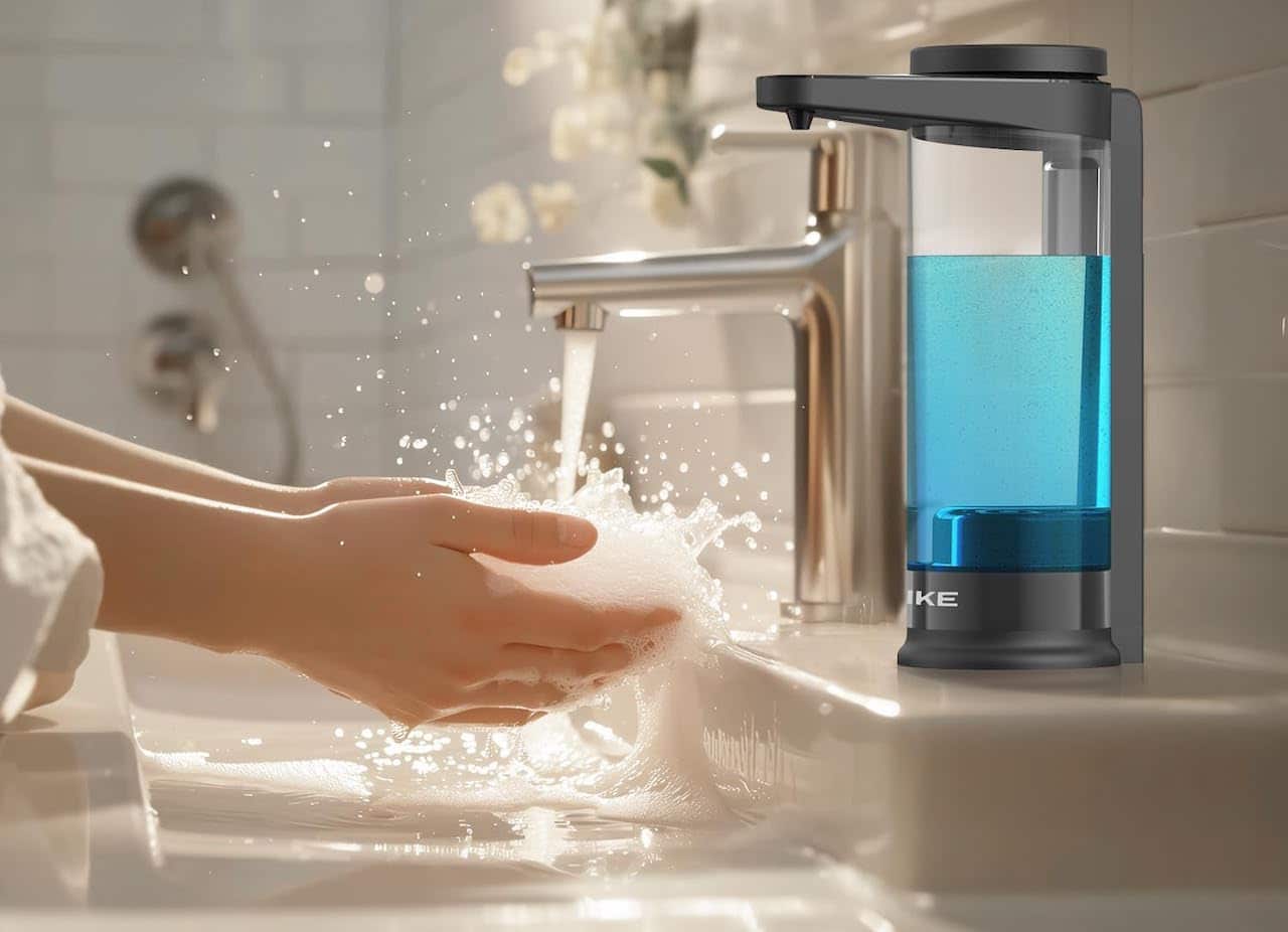 Un distributeur automatique de savon sur le rebord d'un lavabo de salle de bain.