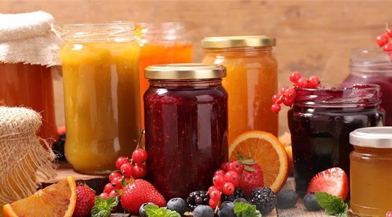 Des pots de confiture sur un plan de travail.
