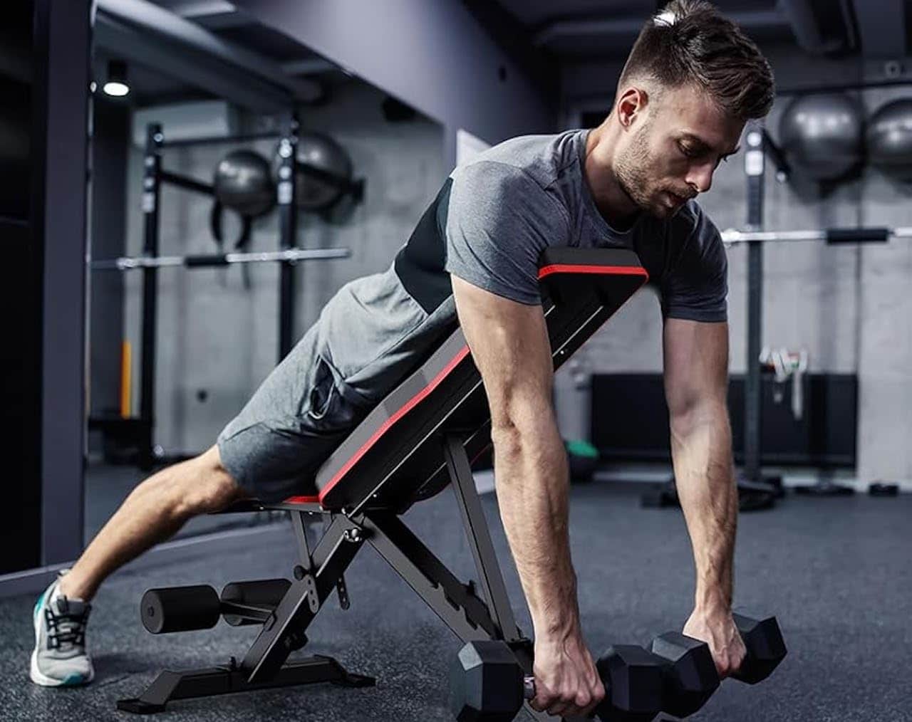 Un homme qui fait du sport sur un banc de musculation dans une salle de sport.