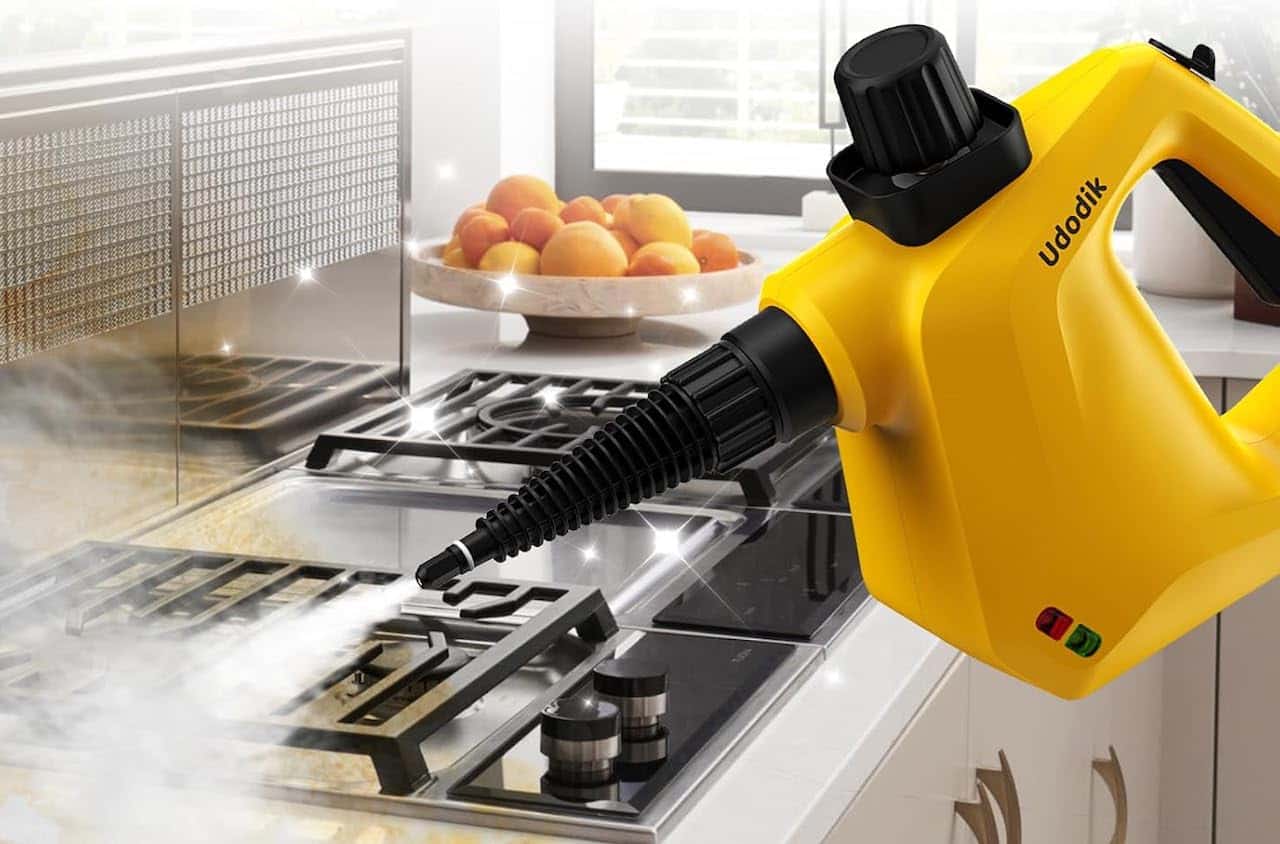 Une nettoyeur vapeur à main qui nettoie une gazinière.