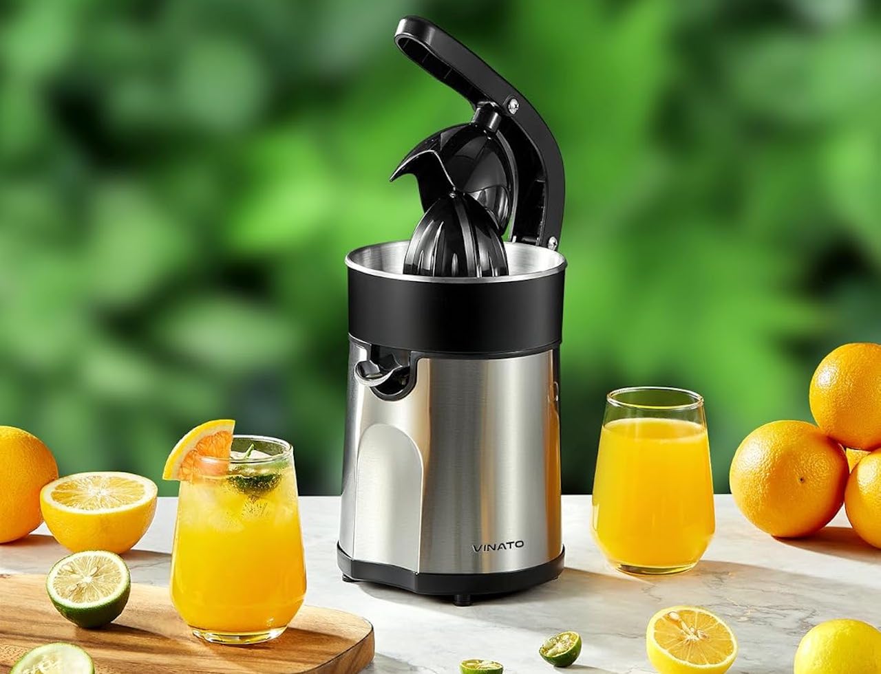 Un presse-agrume et des oranges sur une table de jardin.