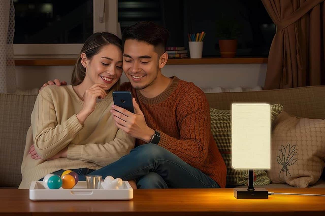 Un coupe assis sur la canapé de leur saloon près d'une lampe de luminothérapie.