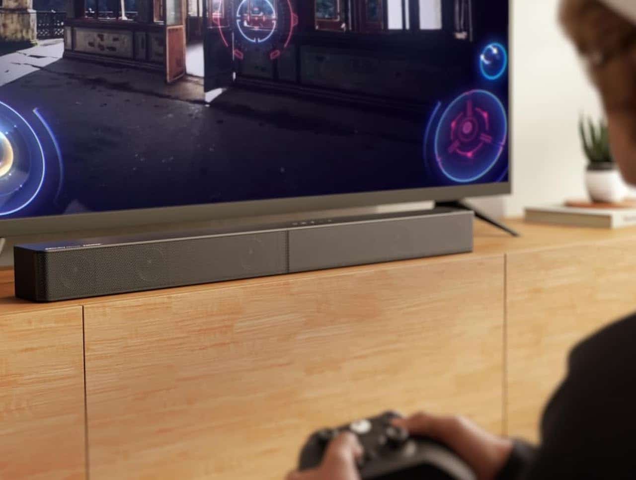 Une barre de son près d'un grand téléviseur.